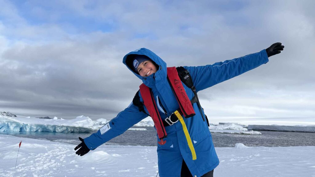 woman in pack of iceberg in antarctica laughing